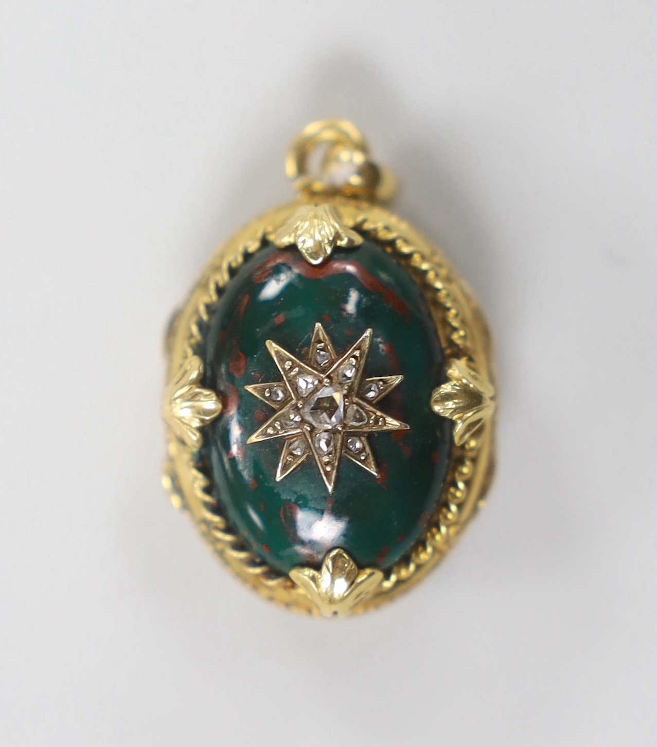 A 1940's? yellow metal and bloodstone set egg shaped mourning pendant, with rose cut diamond set star motif and plaited hair interior, overall 28mm.